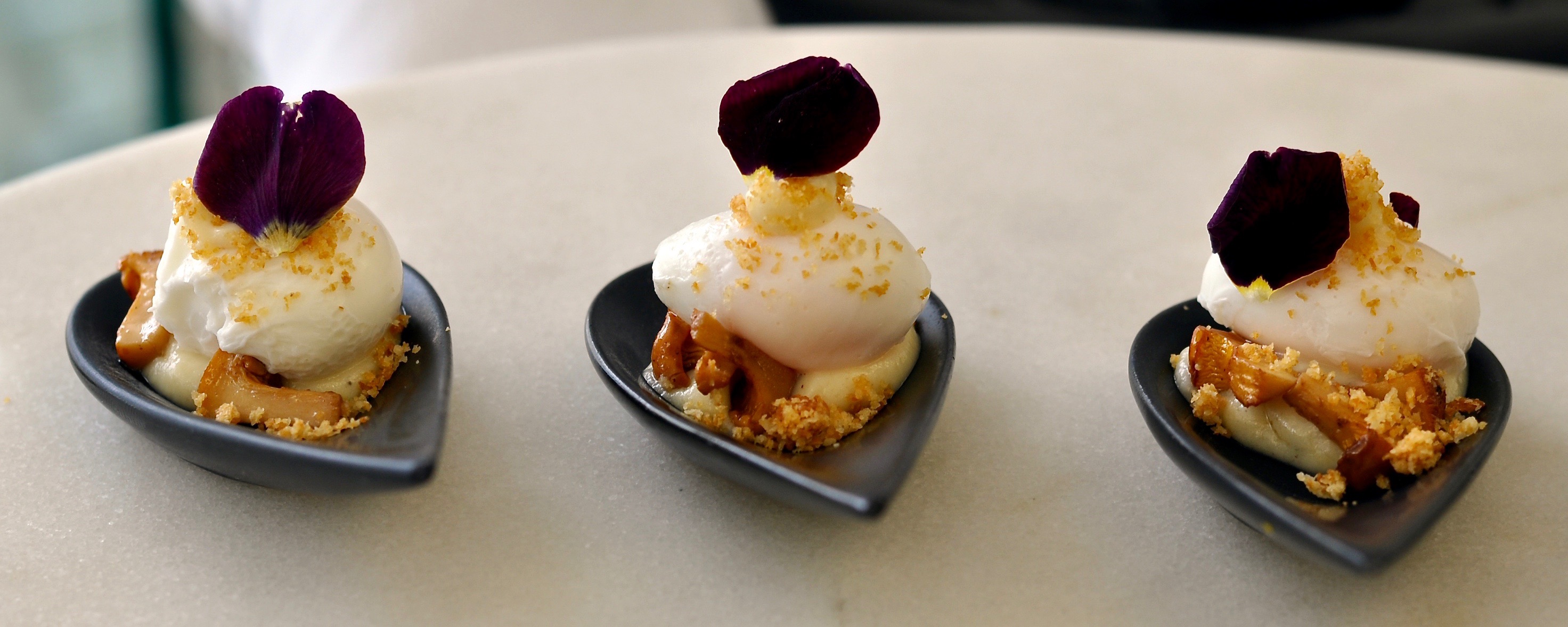 A Blue Strawberry/Table Talk's canapé garnished with viola petals.