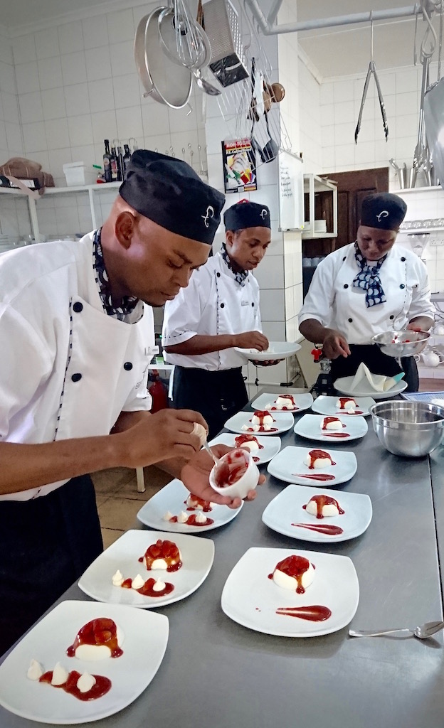 The Elephant Café chefs preparing the Munkoyo Panna Cotta with Seasonal Strawberries & Baby Meringues.