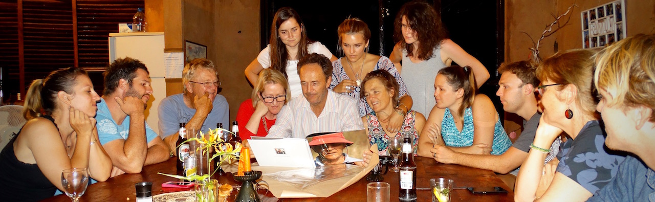 Chris looking at the book Dee made for him, surrounded by his family.